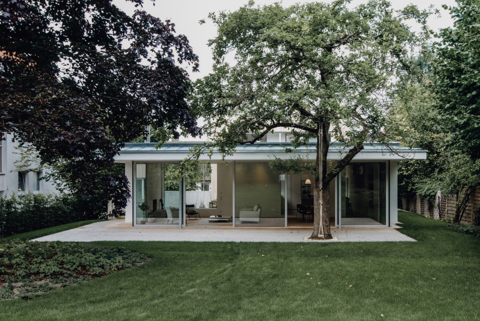 На фото: огромный, двухэтажный, деревянный, белый частный загородный дом в стиле модернизм с плоской крышей и металлической крышей с