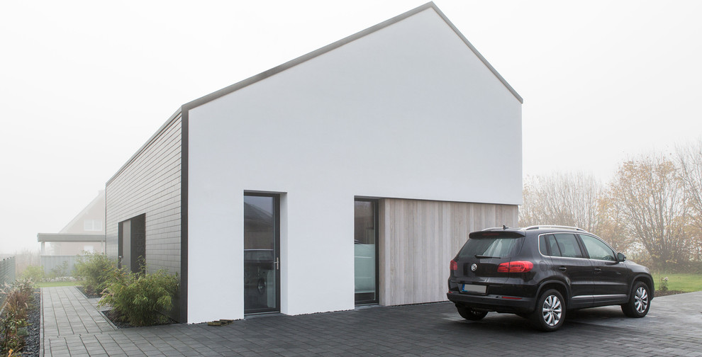 Mittelgroßes, Zweistöckiges Modernes Einfamilienhaus mit Mix-Fassade, weißer Fassadenfarbe, Pultdach und Schindeldach in Hamburg