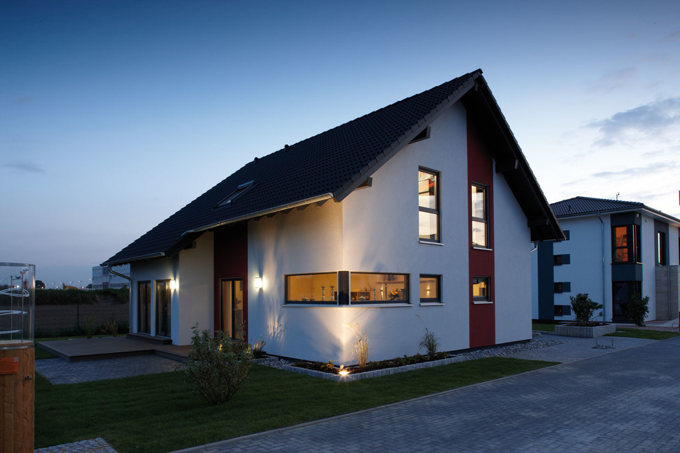 Imagen de fachada de casa blanca contemporánea de dos plantas con revestimiento de estuco, tejado a dos aguas y tejado de teja de barro