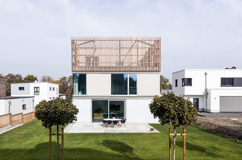 Ejemplo de fachada de casa gris minimalista de tamaño medio de tres plantas con revestimiento de madera, tejado plano y techo verde