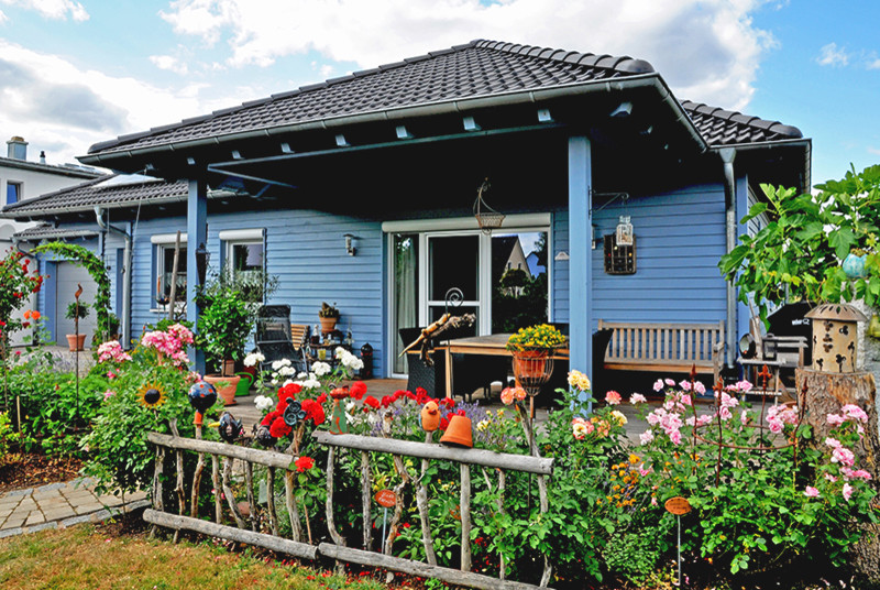 Inspiration pour une façade de maison bleue nordique en bois de plain-pied avec un toit à quatre pans et un toit en tuile.
