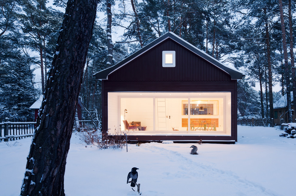 Réalisation d'une façade de maison noire nordique de taille moyenne et à un étage avec un toit à deux pans.