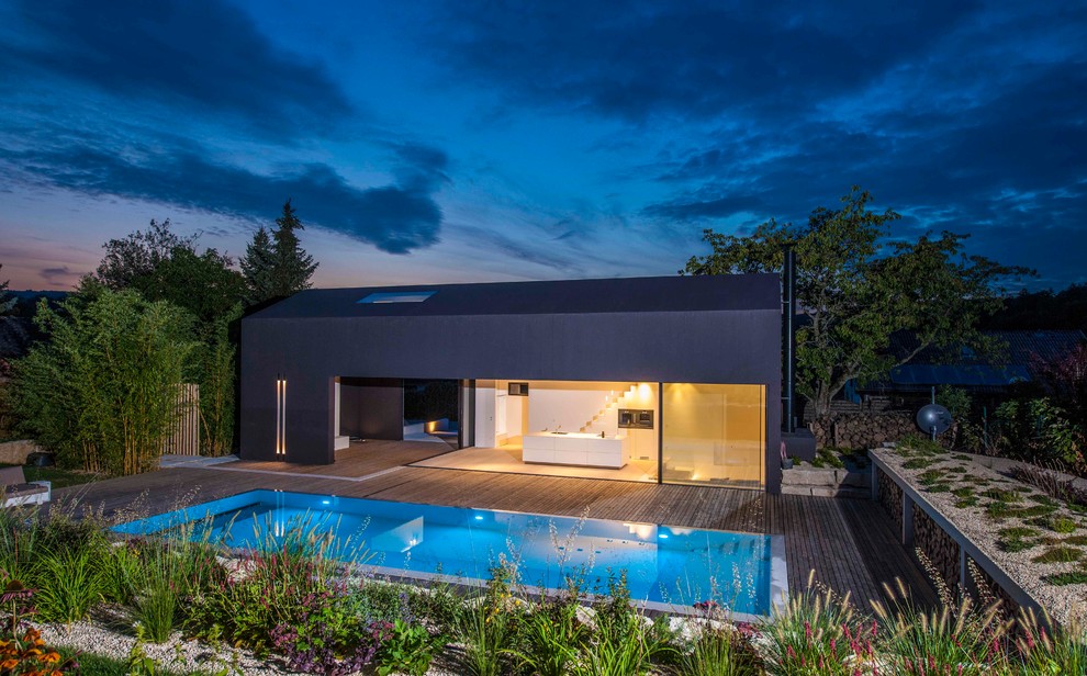Imagen de fachada negra minimalista de tamaño medio de dos plantas con tejado a dos aguas