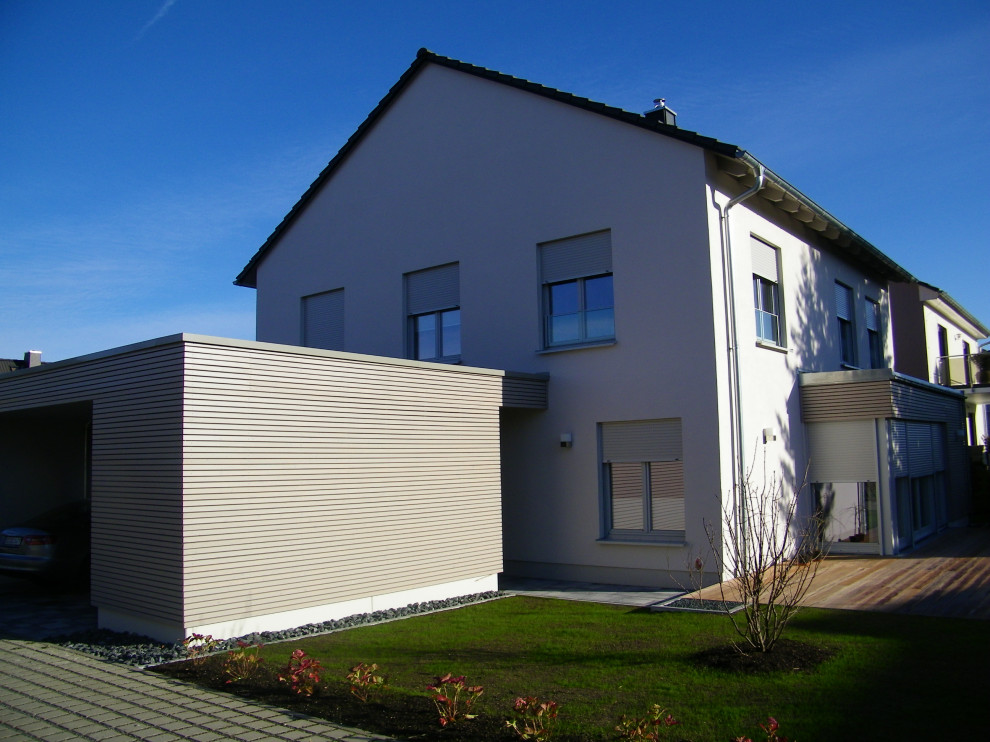 Стильный дизайн: двухэтажный, серый частный загородный дом среднего размера в современном стиле с облицовкой из цементной штукатурки, двускатной крышей и черепичной крышей - последний тренд