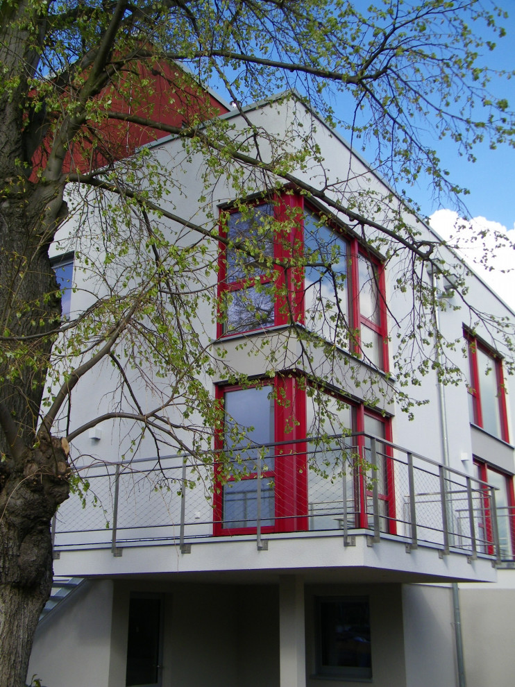 Foto de fachada de casa pareada actual extra grande a niveles con revestimiento de estuco, tejado plano y tejado de varios materiales