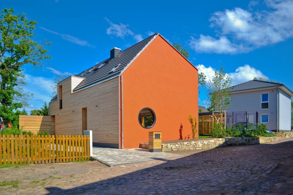 Cette image montre une façade de maison design à un étage et de taille moyenne avec un revêtement mixte et un toit à deux pans.