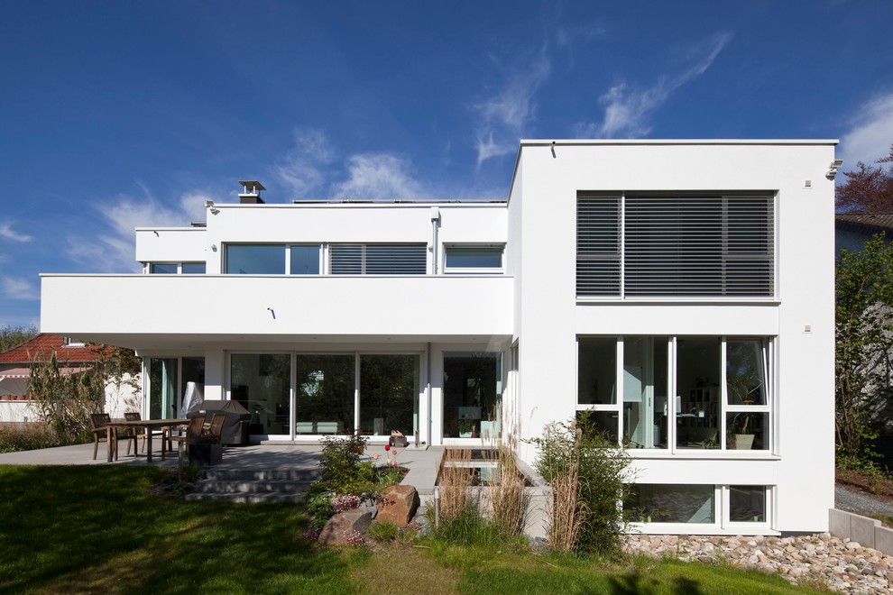 Idee per la facciata di una casa grande bianca moderna a tre piani con tetto piano
