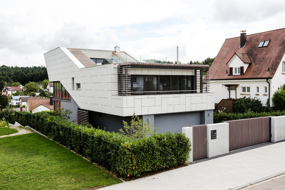 Foto på ett mellanstort funkis vitt hus, med tre eller fler plan, blandad fasad och platt tak