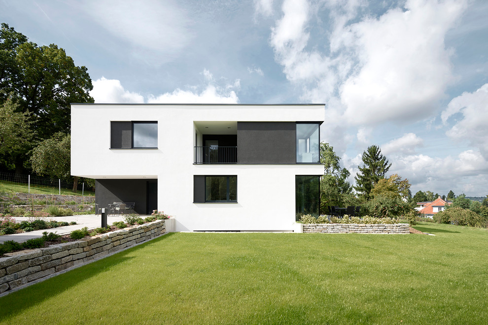 Стильный дизайн: трехэтажный, белый дом среднего размера в современном стиле с плоской крышей - последний тренд