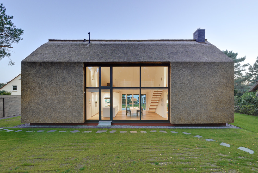 Réalisation d'une petite façade de maison design à un étage avec un toit à deux pans.