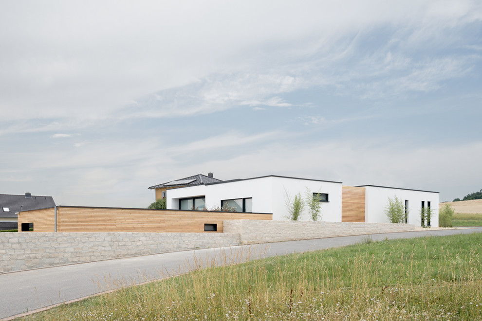 Cette photo montre une grande façade de maison moderne en bois de plain-pied avec un toit plat.