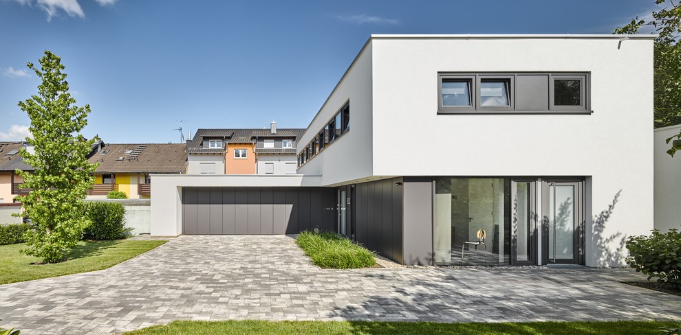 Modelo de fachada de casa gris contemporánea grande de dos plantas con revestimiento de estuco y tejado plano