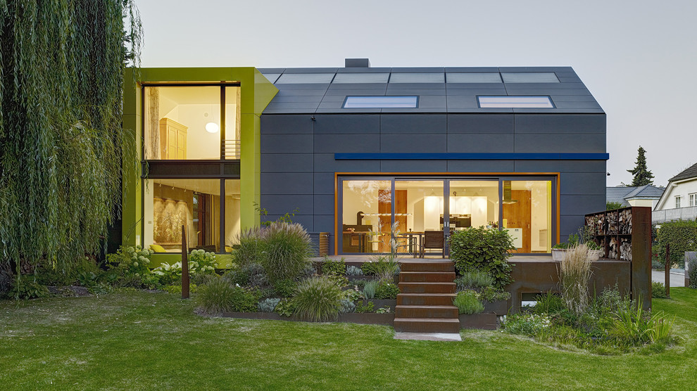 Mid-sized contemporary green two-story gable roof idea in Frankfurt