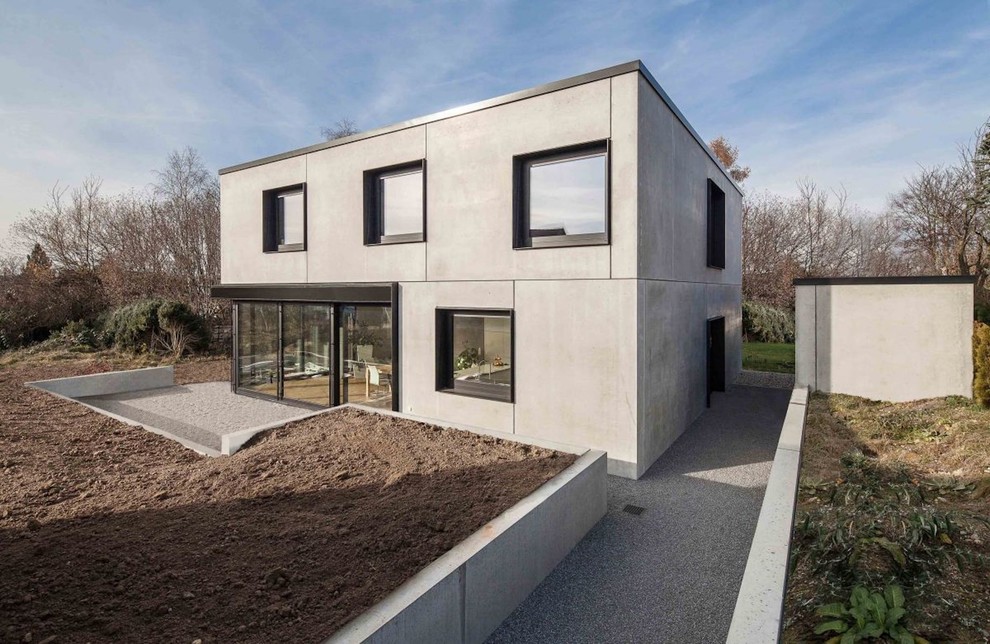 Идея дизайна: большой, двухэтажный, серый частный загородный дом в стиле модернизм с облицовкой из бетона и плоской крышей