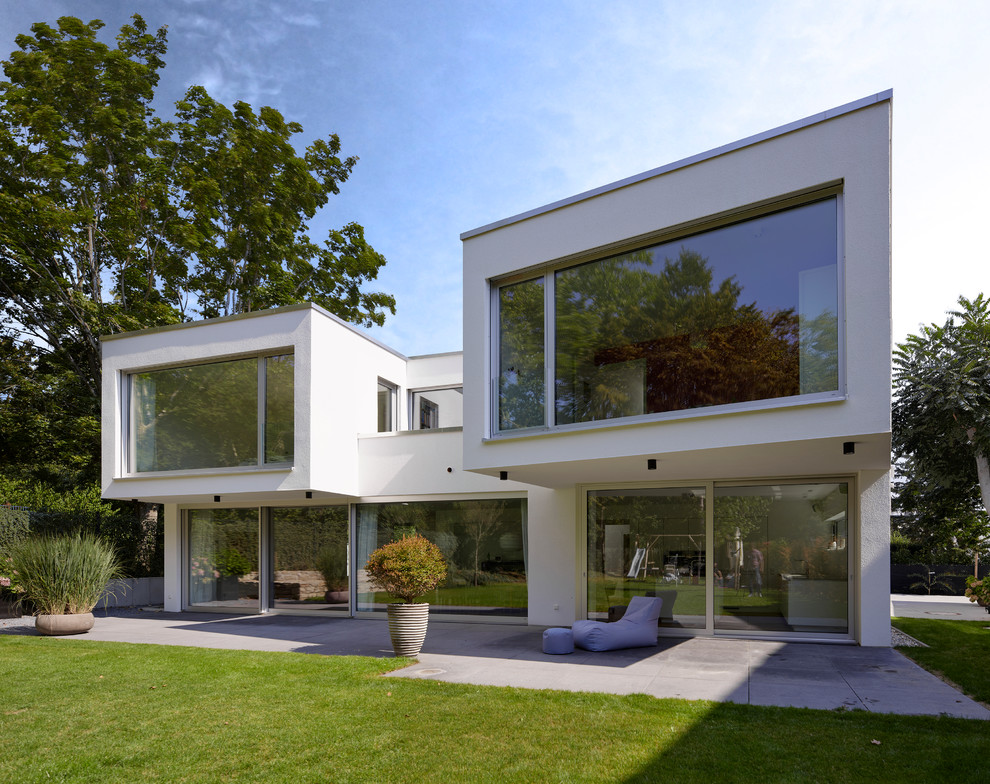 Idée de décoration pour une façade de maison blanche design à niveaux décalés et de taille moyenne avec un toit plat.