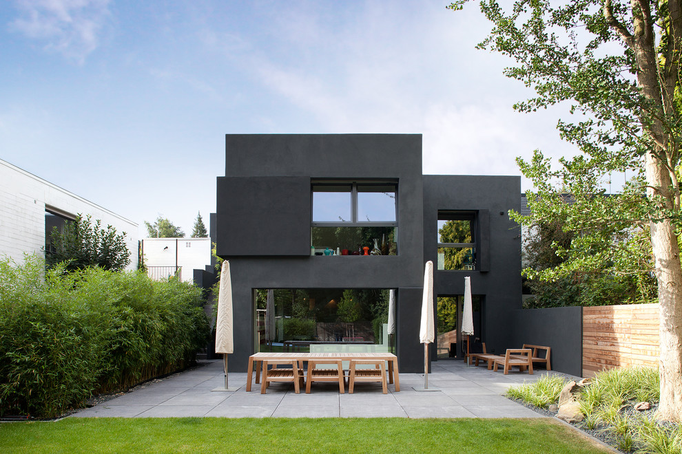 Modelo de fachada negra minimalista de tamaño medio de dos plantas con tejado plano