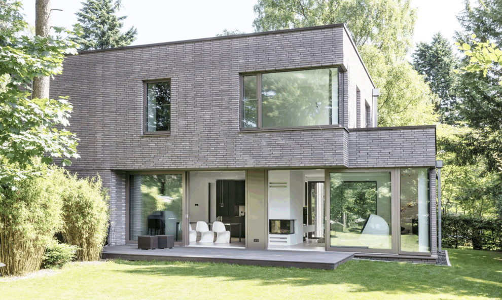 Medium sized and beige contemporary two floor brick terraced house in Hamburg with a flat roof.