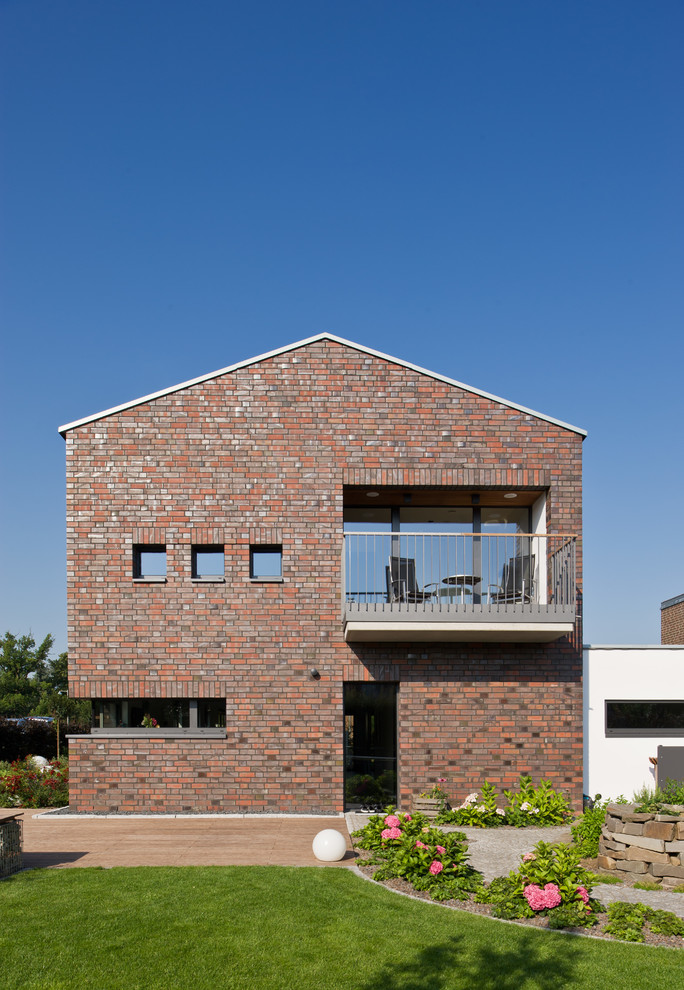 Idee per la facciata di una casa rossa contemporanea a due piani di medie dimensioni con rivestimento in mattoni e tetto a capanna