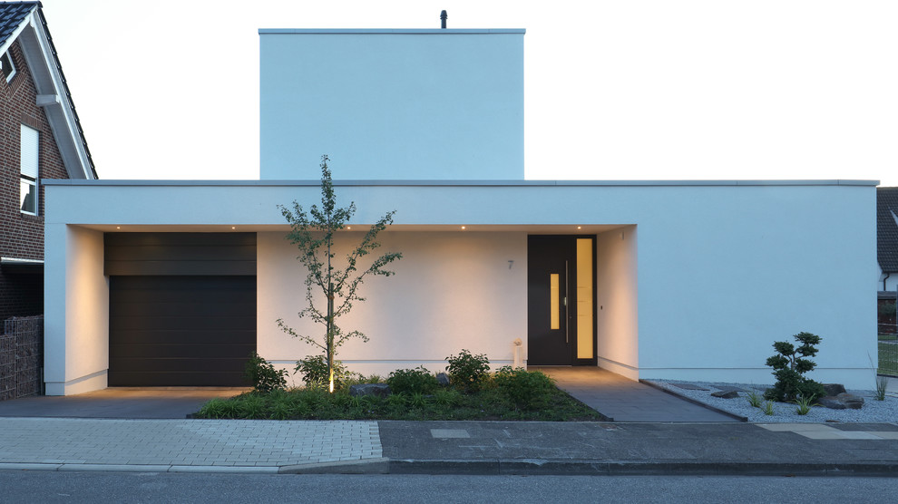 Идея дизайна: маленький, двухэтажный, белый частный загородный дом в современном стиле с облицовкой из цементной штукатурки, плоской крышей и крышей из смешанных материалов для на участке и в саду
