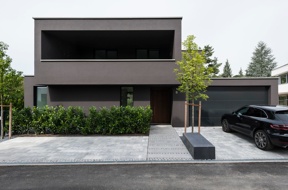 На фото: большой, двухэтажный, серый частный загородный дом в стиле модернизм с облицовкой из цементной штукатурки, плоской крышей и зеленой крышей