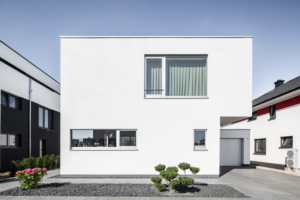 Zweistöckiges, Mittelgroßes Modernes Haus mit Flachdach und weißer Fassadenfarbe in Köln