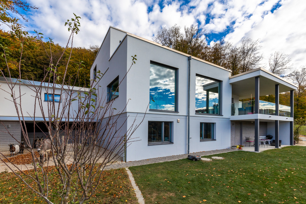 Großes, Dreistöckiges Modernes Einfamilienhaus mit Putzfassade, weißer Fassadenfarbe und Flachdach in Berlin