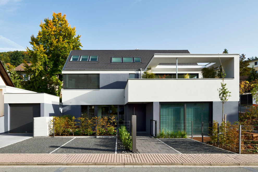 Inspiration for a large and white contemporary house exterior in Frankfurt with three floors and a pitched roof.