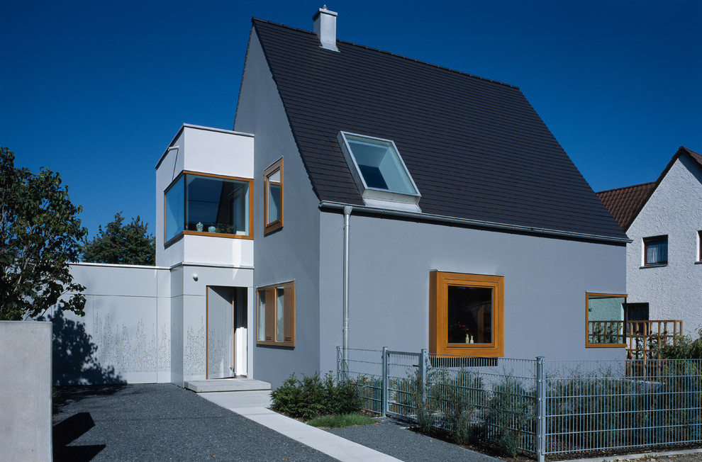 Mittelgroßes, Zweistöckiges Modernes Haus mit grauer Fassadenfarbe und Satteldach in München