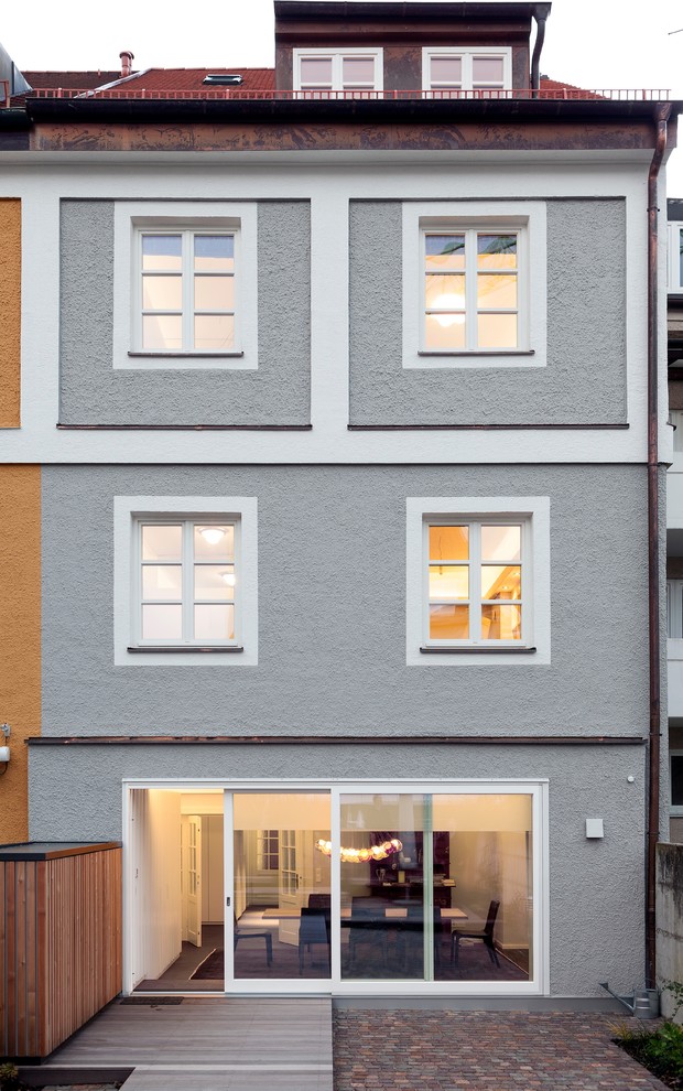 Aménagement d'une façade de maison grise contemporaine de taille moyenne et à deux étages et plus avec un toit à deux pans.