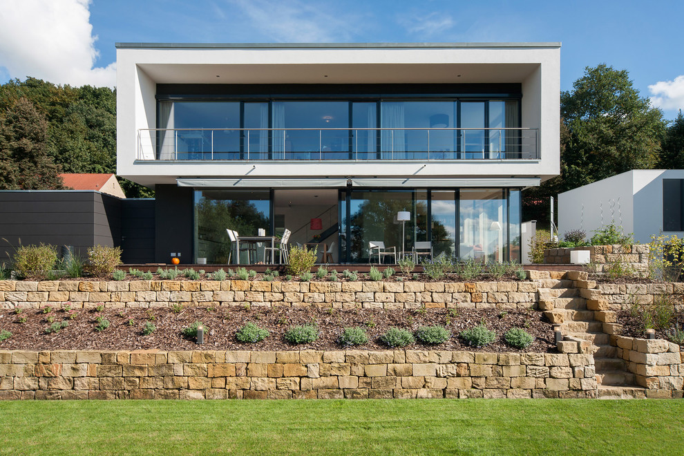 Diseño de fachada blanca moderna de tamaño medio de dos plantas con tejado plano