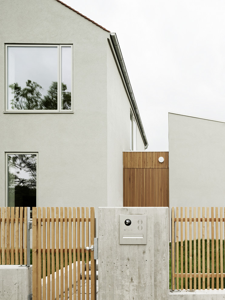 Inspiration for a medium sized and gey contemporary two floor house exterior in Berlin with mixed cladding and a pitched roof.