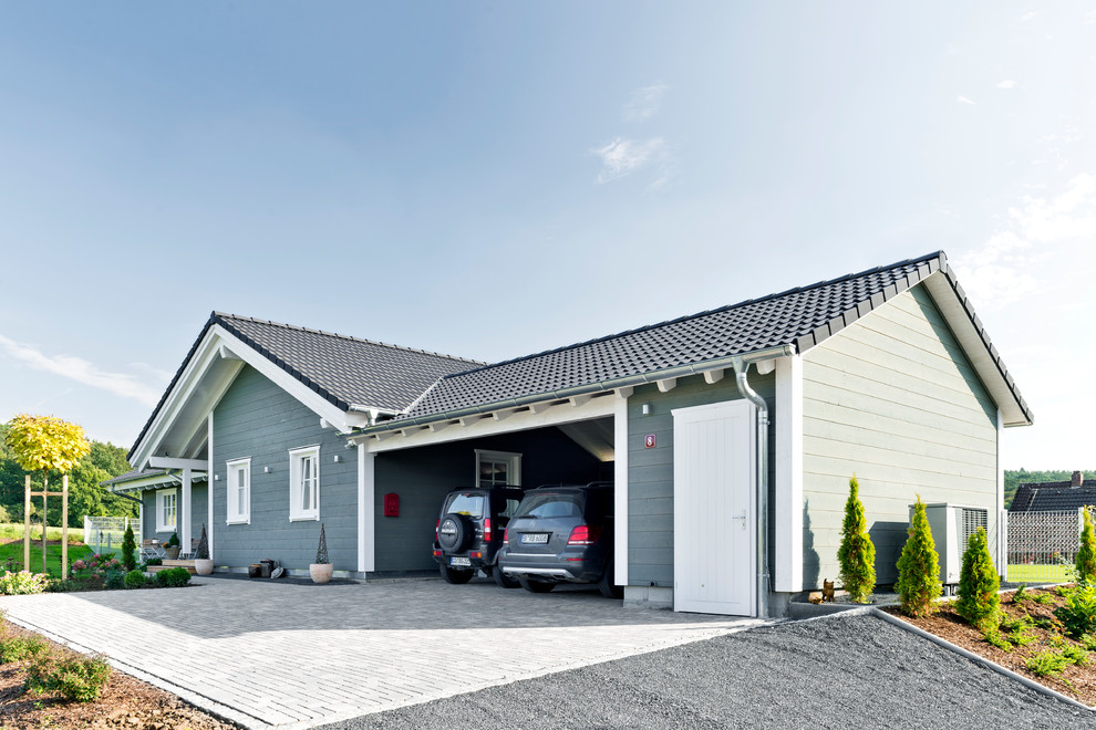 Cette photo montre une façade de maison grise nature en bois de plain-pied avec un toit à deux pans et un toit en tuile.