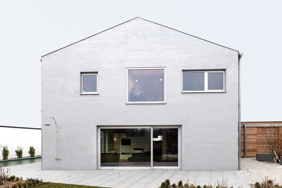 Idéer för att renovera ett mellanstort funkis grått hus, med två våningar och sadeltak