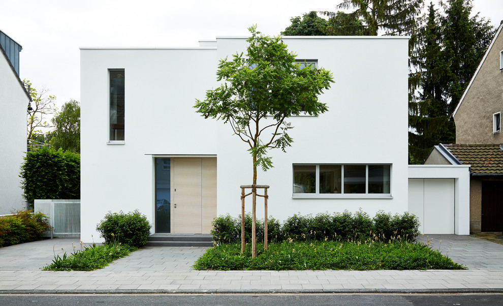 На фото: двухэтажный, белый дом среднего размера в стиле модернизм с плоской крышей