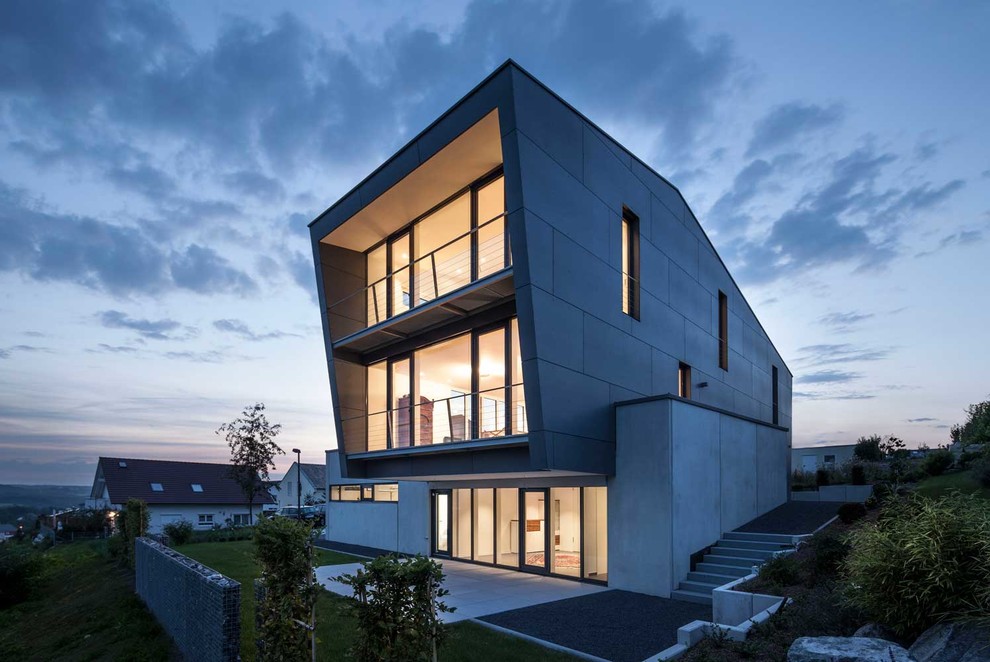 Geräumiges, Dreistöckiges Modernes Haus mit grauer Fassadenfarbe, Pultdach und Betonfassade in Sonstige