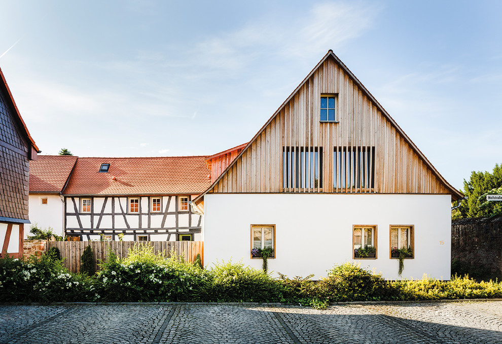 Cette photo montre une façade de maison marron nature en bois à un étage avec un toit à deux pans.