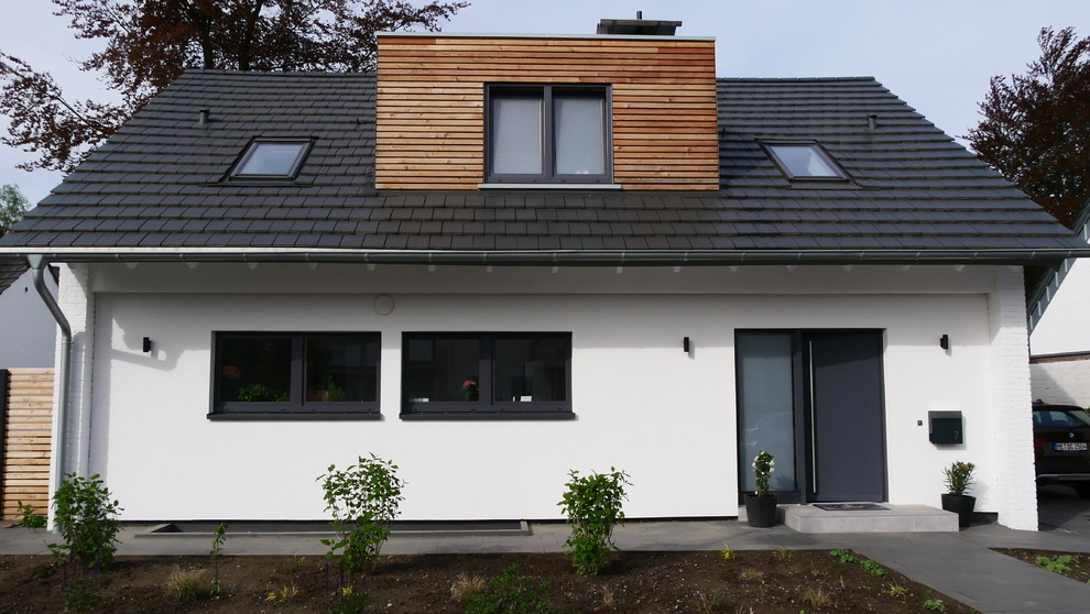 Kleines, Zweistöckiges Modernes Einfamilienhaus mit Putzfassade, weißer Fassadenfarbe, Satteldach und Ziegeldach in Düsseldorf