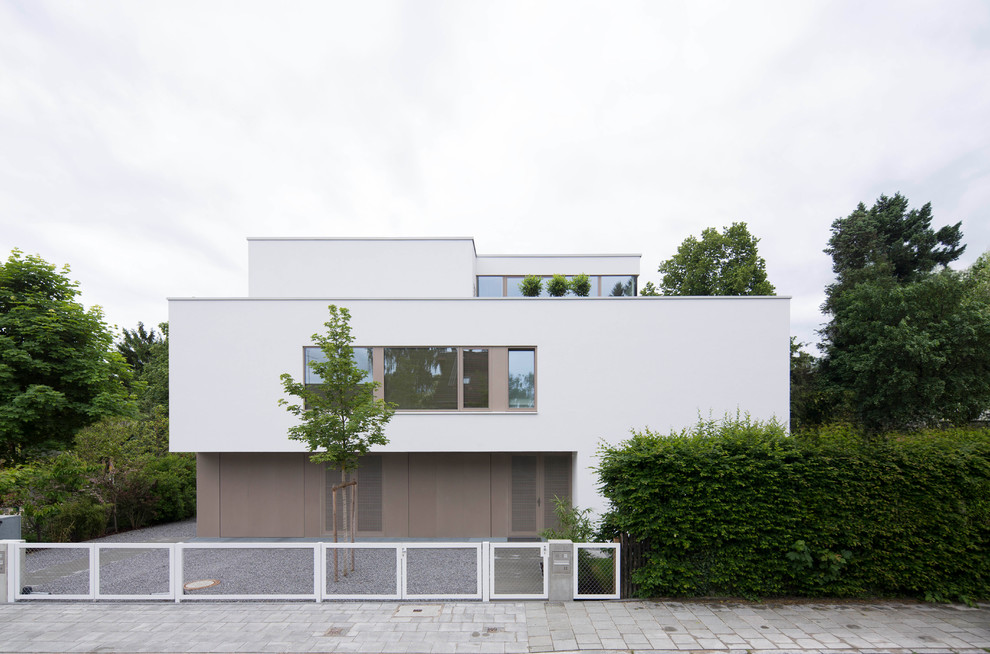 Photo of a large and white contemporary concrete house exterior in Munich with three floors and a flat roof.