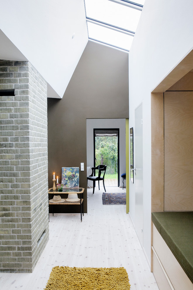 Bild på en mellanstor minimalistisk hall, med flerfärgade väggar och ljust trägolv