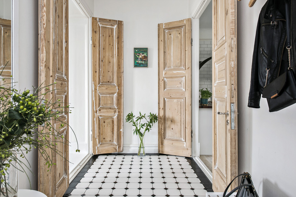 Inredning av en minimalistisk mellanstor hall, med vita väggar och flerfärgat golv