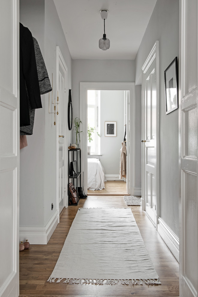 Foto de recibidores y pasillos clásicos de tamaño medio con paredes blancas y suelo de madera en tonos medios