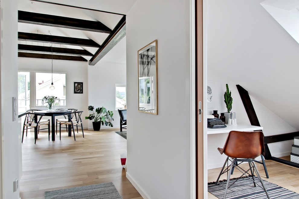 Bild på en mellanstor minimalistisk hall, med vita väggar och ljust trägolv