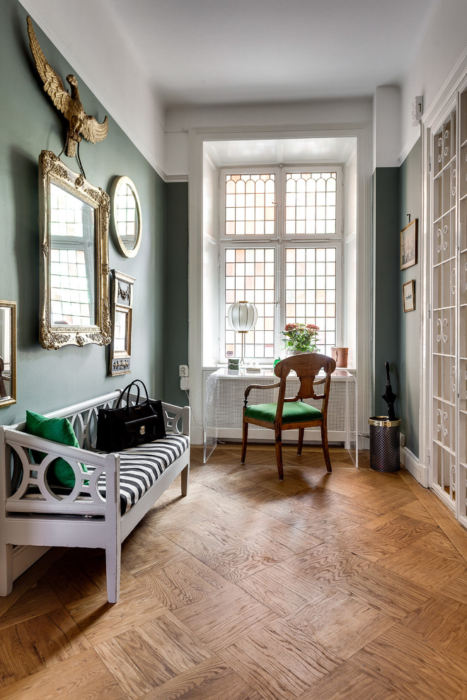 Kleiner Klassischer Flur mit grüner Wandfarbe und braunem Holzboden in Stockholm