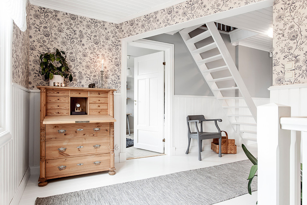 На фото: большой коридор в скандинавском стиле с серыми стенами, деревянным полом и белым полом