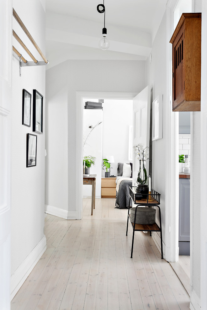 На фото: маленький коридор в скандинавском стиле с деревянным полом и белым полом для на участке и в саду с