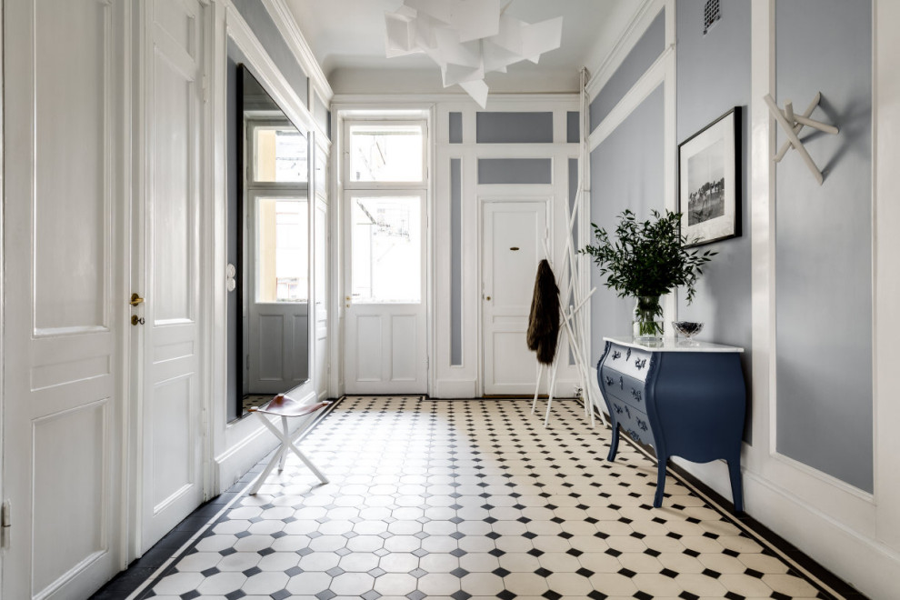 Inspiration for a mid-sized victorian ceramic tile and white floor hallway remodel in Stockholm with blue walls