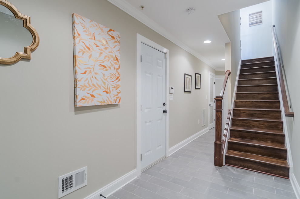 Cette image montre un grand couloir traditionnel avec un mur beige, un sol en ardoise et un sol gris.