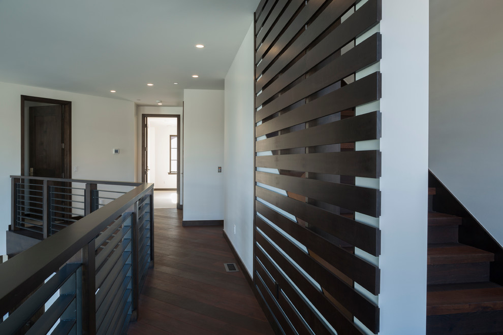Hallway - transitional medium tone wood floor hallway idea in Boise with white walls