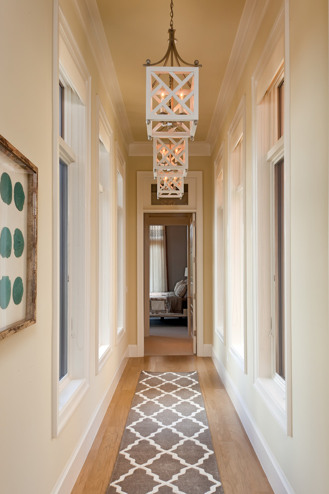 Immagine di un ingresso o corridoio chic con pareti beige e pavimento in legno massello medio