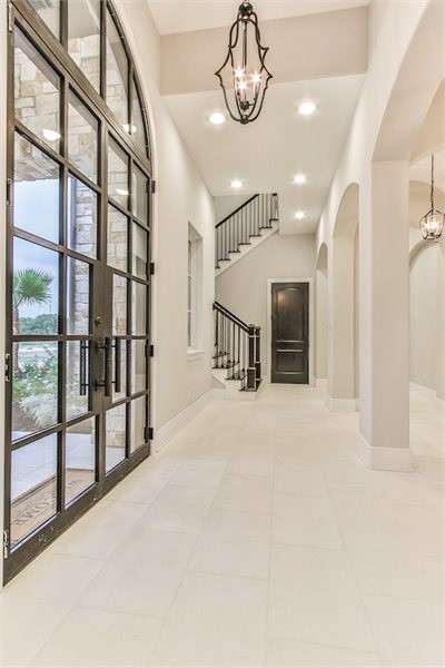 Идея дизайна: большой коридор в стиле неоклассика (современная классика) с белыми стенами, полом из известняка и белым полом